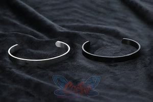 Genshin Impact Xilonen cosplay hand cuffs pair a matte silver open cuff alongside a matching flat black open cuff.