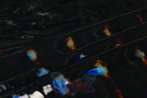Genshin Impact Xilonen cosplay fabric detail centers iridescent light scatter across dark shimmering textile.