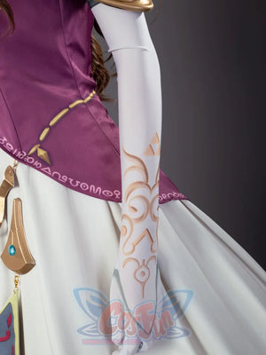 Twilight Princess Zelda cosplay glove traces gold-patterned detail along white fabric beside a decorative belt.