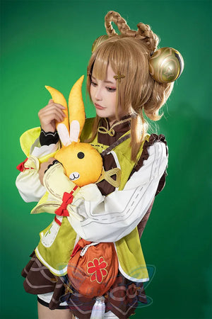 Genshin Impact Yaoyao cosplay top layers yellow-green vest over ruffled white blouse beside plush animal prop.