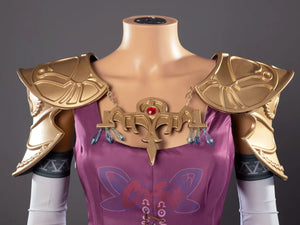 Twilight Princess Zelda cosplay chest ornament drops teal dangles beneath gold shoulder pieces above magenta top.
