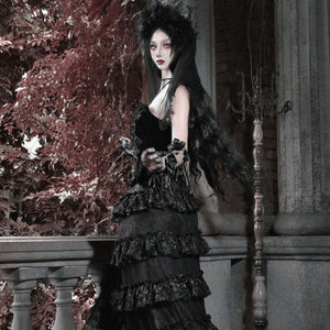 Model in all-black gothic velvet corset bustier top with ruffled tiered skirt, floral headpiece, and black rose in hand.