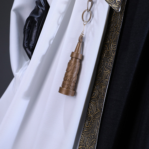 There is a belt with a metal chain and decorations at the waist and bells, an ornament is hung on the chain.