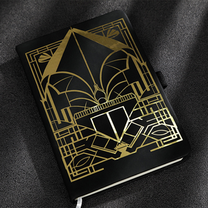 The notebook has a black cover with gold geometric patterns.