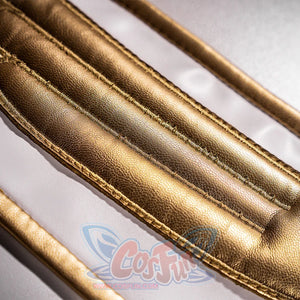 Anime Lelouch cosplay panel detail traces raised stitched channels of textured gold faux leather across white fabric.