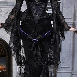 Close-up of gothic black mermaid skirt with lace embroidery, floral applique, and a purple velvet sash belt.