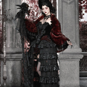 Model in black gothic velvet corset bustier top and tiered skirt, draped with a red faux fur wrap and black rose headpiece.
