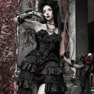 Model wearing a black gothic velvet strapless corset bustier top with lace-up front, floral details, and layered necklaces.