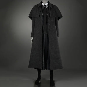 The coat is a long double-breasted coat with a shawl design on the shoulders and a plaid pattern. Inside is a striped suit, a knitted vest and a shirt. Below is a black pleated long skirt and black socks.