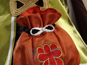 Genshin Impact Yaoyao cosplay pouch centers red embroidered crest and white braided cord beside green gold-trim jacket.