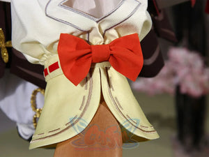 Genshin Impact Yaoyao cosplay sleeve cuff pairs red and yellow fabric trim beside prominent red bow on white blouse.
