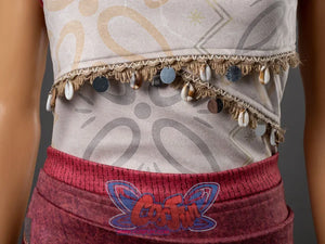 Moana cosplay costume waist close-up showing decorative shell and coin fringe trim at the hem of the patterned top