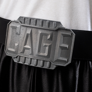 Belt buckle embossed with “CAGE”, highlighting the character’s signature style.