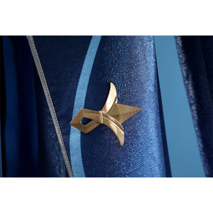 Neuvillette cosplay coat detail with gold star-shaped decorative pin on navy blue sleeve fabric