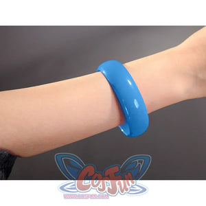 Robin cosplay accessory showing a single blue bangle bracelet worn on a wrist against a gray background
