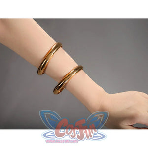 Robin cosplay accessory close-up showing two gold bangles worn on a wrist against a gray background