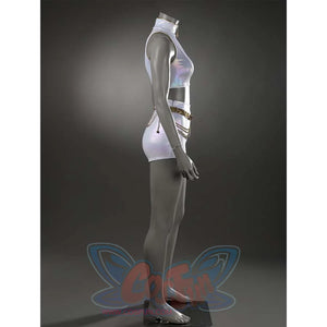 Angled view of the white stage set, emphasizing the iridescent fabric of the high - neck top and shorts, along with the decorative gold belt.