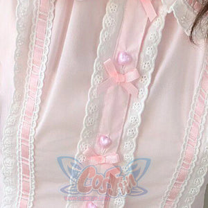Close-up of pink Lolita blouse placket featuring white lace trim, pink satin ribbon, and heart pearl buttons.