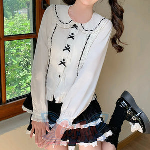 White-black Lolita blouse with black-trimmed Peter Pan collar, black heart buttons with bow decoration, and ruffled lace cuffs, full figure view.