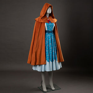 Holly cosplay back view showing yellow-brown hooded cloak, blue floral dress with white bodice and hem