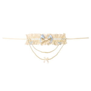 Pearl necklace flat lay with butterfly bow, lace band, and chain drape