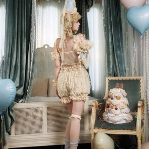 Side styling view of cream pumpkin bloomers with rounded ruffle silhouette