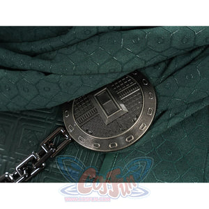 Doctor Doom cosplay cape clasp detail with a round dark ornament and attached chain.