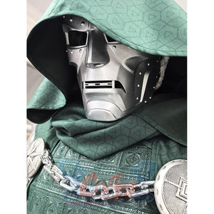 Doctor Doom cosplay mask centers silver-tone facial armor with green hooded textured cloak and metal chest chain.
