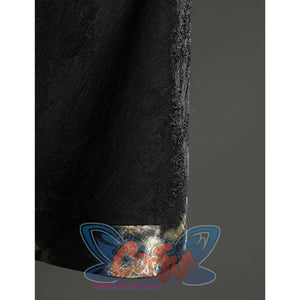 Close-up of the Fire Keeper cape hem showing the black textured fabric and softly reflective metallic edge trim.