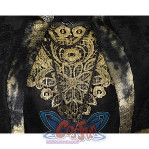 Close-up of the Fire Keeper costume gold chest embroidery beneath the cape, framed by dark metallic trimmed panels.