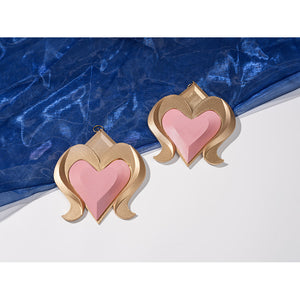 Genshin Impact Snezhnaya Odette cosplay heart charms flat lay places pink pendants over blue sheer fabric.