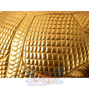 Gold-tone armored cosplay chest texture close-up centers quilted scales around the raised chest panel.