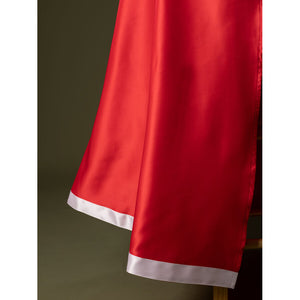Detail of Charlie Morningstar prom dress skirt hem with red satin fabric, white edge trim and long flowing panel