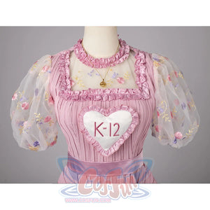 Melanie Martinez K-12 Cry Baby cosplay bodice frames the heart bib below floral sheer sleeves.