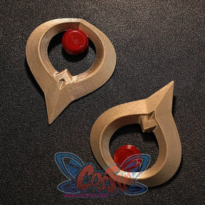 Flat lay of Sandrone cosplay costume gold ornaments with red round centers and curved metal-look shapes