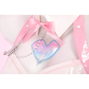 Wuthering Waves Aemeath cosplay heart patch detail sits below a pink bow tie, framed by glossy straps and chain.