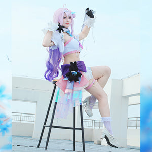 Wuthering Waves Denia cosplay costume seated view sets the white jacket above a side plush, bow, and skirt shorts.