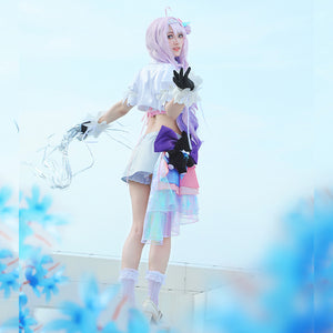 Wuthering Waves Denia cosplay costume side view frames the skirt shorts with a black bear plush and iridescent ribbon.