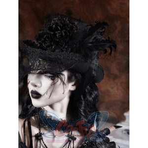 Close-up detail of the Gothic Victorian flat-top hat showing the black rose embroidery, layered black fabric flowers, and feather decorations on the crown