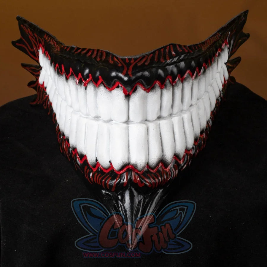 A tight close-up zooms on the Body Party helmet’s mouth—large white teeth, red detailing, and a sharp downward tip—poised on a dark surface.