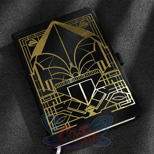 The notebook has a black cover with gold geometric patterns.