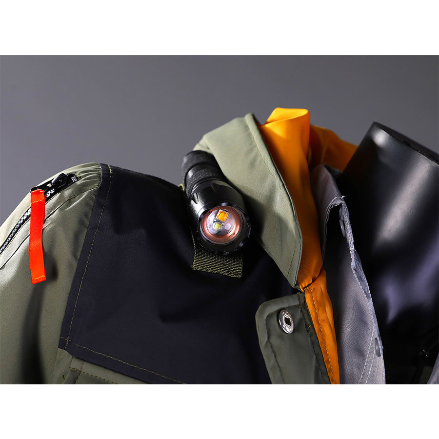 Close-up detail of Kyle Crane cosplay costume necklace with circular pendant, orange hood lining, and jacket shoulder accessories