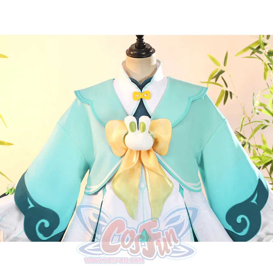 Genshin Impact Yaoyao cosplay coat frames plush rabbit bow chest accent over patterned dark blue cuffed sleeves.