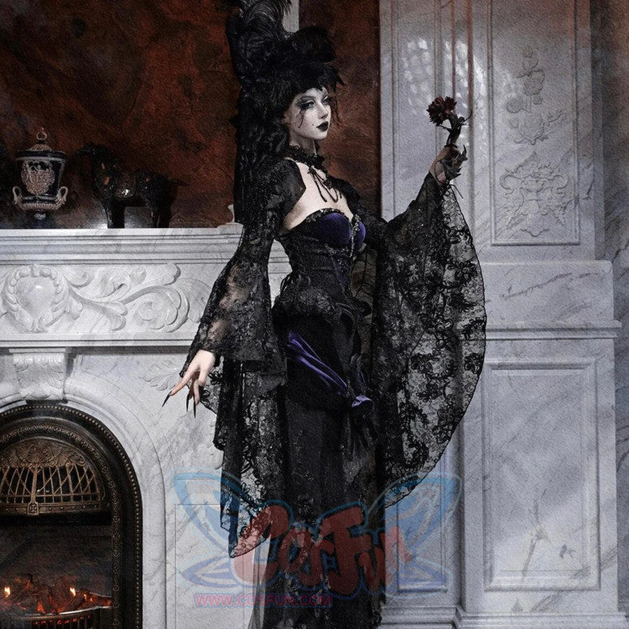 Model in a gothic black lace robe with purple corset, feathered hat, holding a small dark rose by a fireplace.