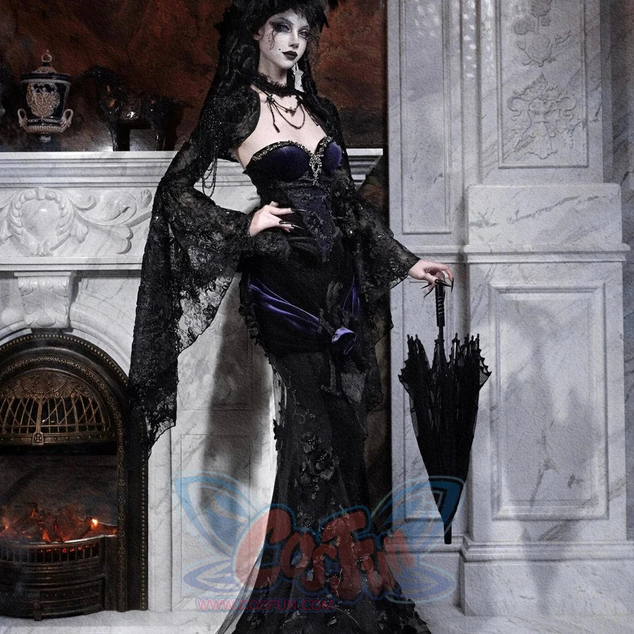Model in a gothic black lace mermaid skirt with purple corset, holding a closed black umbrella by a fireplace.