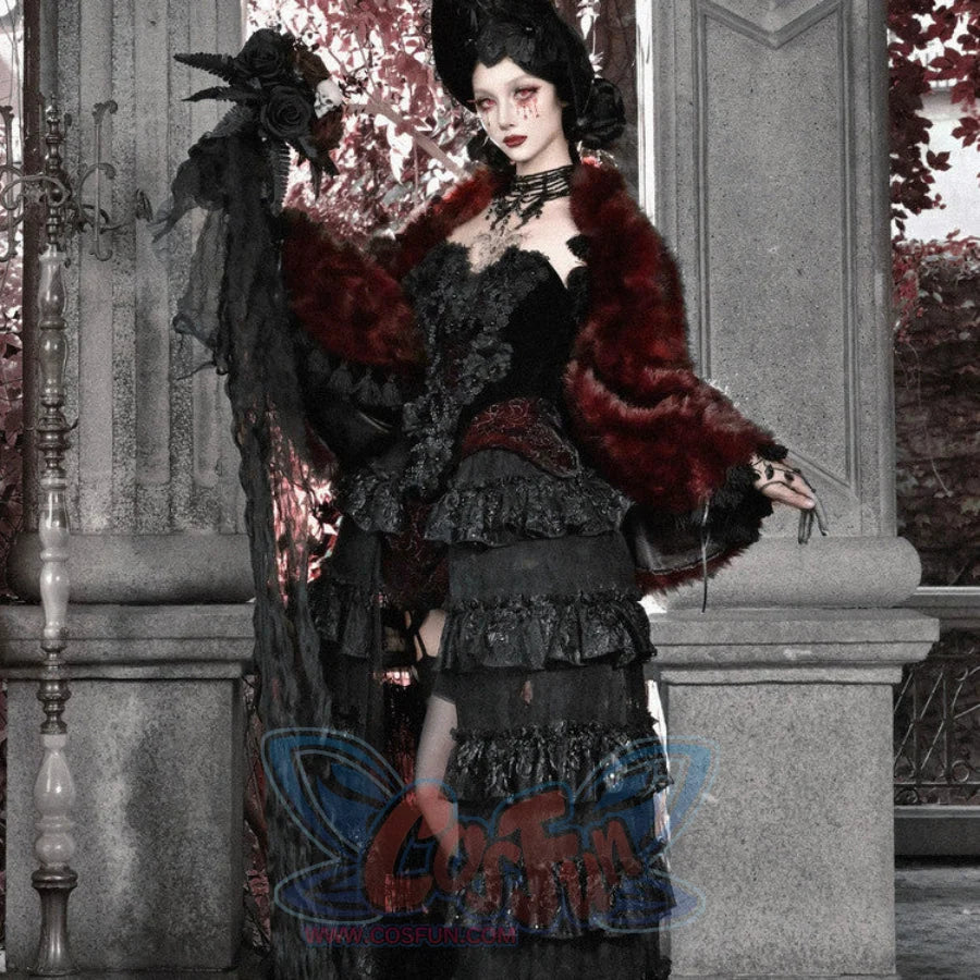 Model in black gothic velvet corset bustier top and tiered skirt, draped with a red faux fur wrap and black rose headpiece.