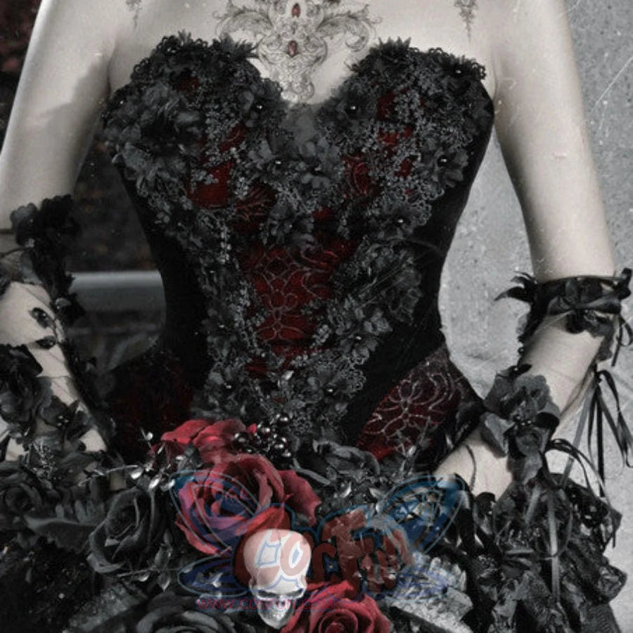 Close-up of gothic corset bustier top with red brocade panel, black floral appliques, and bouquet with red roses and skull.