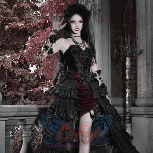 Model in gothic black velvet corset bustier top with red brocade mini skirt, ruffled layers, floral crown, and lace gloves.