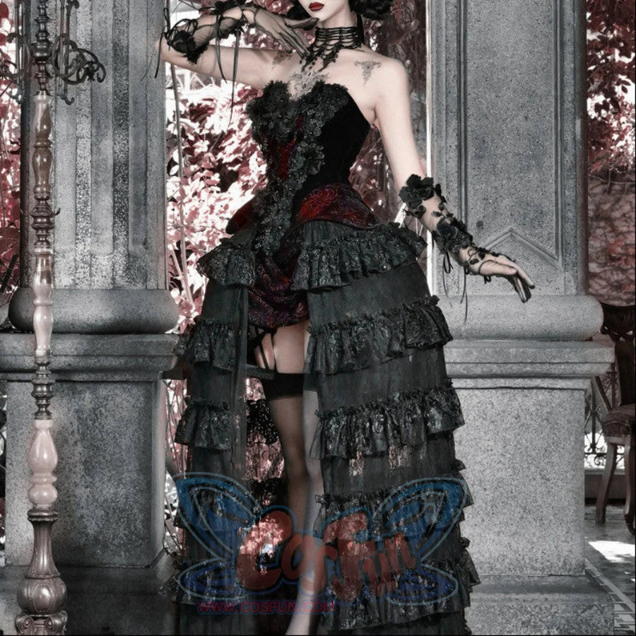 Model posing in a black gothic corset bustier top with red brocade accent and multi-tiered ruffled skirt, black stockings.