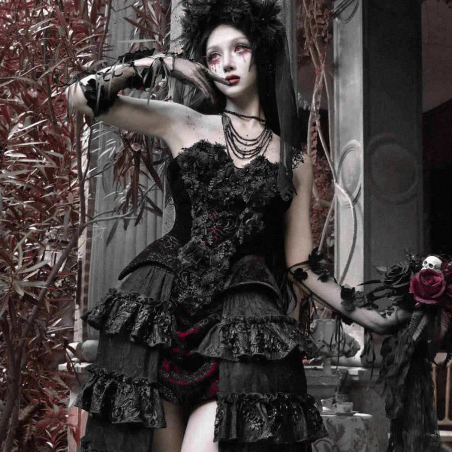 Model wearing a black gothic velvet strapless corset bustier top with lace-up front, floral details, and layered necklaces.